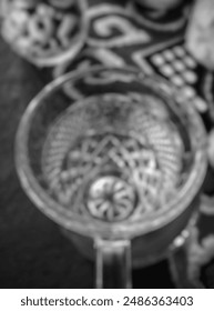 Closeup of small clear drinking cup glass, flat lay. Vintage, bokeh
