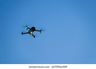 Close-up of a small glowing drone hovering in the evening.