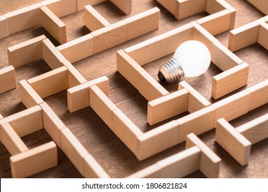 Closeup Small Light Bulb In The Maze Game Built By Wood Blocks, Finding The Right Way To The Success, Searching Creative Idea Concept