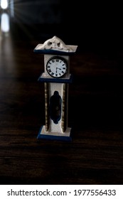 Close-up Of Small Old Dollhouse Grandfather Clock On Wooden Floor