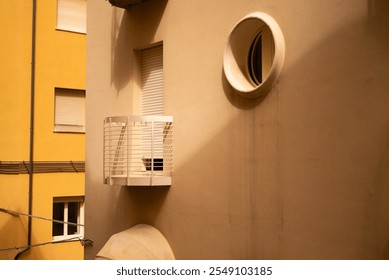 Close-up of a small round window with brick frame and iron security bars. Hotel in Rimini, Italia