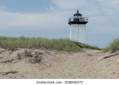 A Closeup Of A Small Sandy Hill With A Lighthouse In The Background  Cape Cod, Massachusetts 