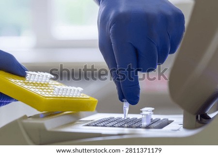 Close-up of small test tubes with samples being placed into a laboratory apparatus for PCR analysis.