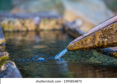 closeup small wellspring, flow into a pipe