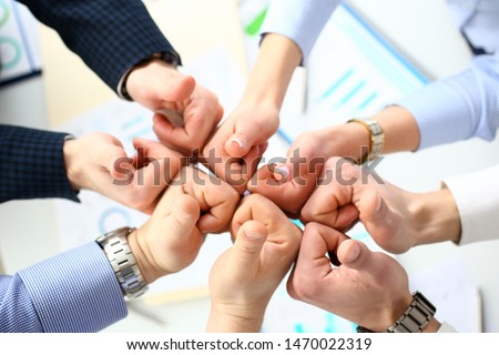 Close-up of smart people performing cooperation gesture to greet presumptive boss or colleagues and show increased level of cohesion and solidarity. Company meeting concept