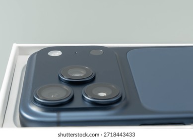 Close-up of a smartphone camera system with three lenses and flash on a matte back surface. Soft lighting showcases precision engineering and modern aesthetics.