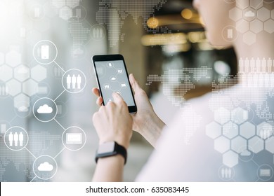 Close-up Of Smartphone In Female Hands.In Foreground Are Virtual Icons With Picture Of Clouds,people And Digital Gadgets.Social Media.Girl Blogging,chatting Online.Cloud Technology.Blurred Background.