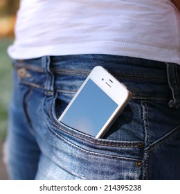 close-up smartphone in pocket of girl's jeans