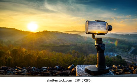 Close-up Smartphone take a Mountians Landscape photo and video timelapse on stand  Mobile Stabilizer in sunset - Powered by Shutterstock