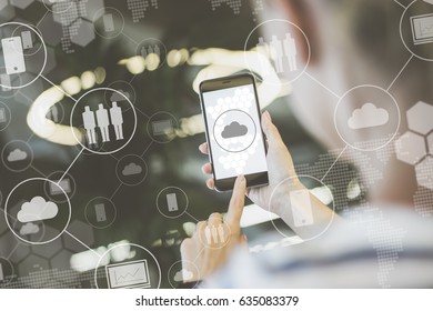 Close-up of smartphone in woman's hands.Selective focus.In foreground are virtual icons with clouds,people,gadgets.Social media. Girl blogging, working, shopping, chatting online. Blurred background. - Shutterstock ID 635083379