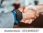 Closeup of smartwatch, handshake, partners