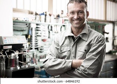 Close-up of a smiling mechanic inside his auto repair shop - Powered by Shutterstock