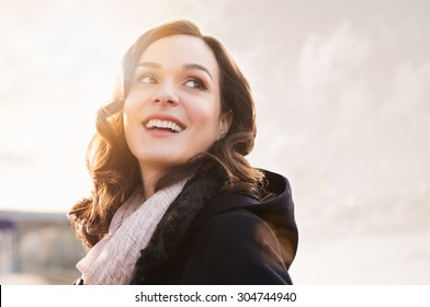 Closeup of smiling thinking woman looking away outdoor