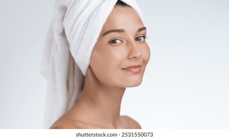 A close-up of a smiling woman with radiant skin, wrapped in a towel turban after completing her skincare routine. Perfect for beauty, skincare, and wellness promotions focusing on natural beauty and - Powered by Shutterstock