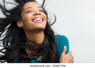 Closeup of smiling young woman with hair in the wind - Shutterstock ID 255827704