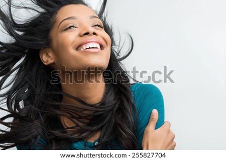 Closeup of smiling young woman with hair in the wind

