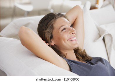 Closeup of a smiling young woman lying on couch