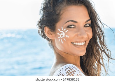 Closeup Of Smiling Young Woman With Suncream On Face At Sea