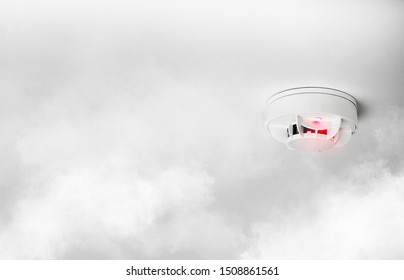 Close-up Of Smoke Alarm Or Smoke Detector In Home Going Off With Thick Smoke