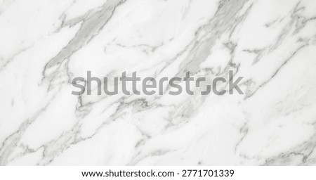 Close-up of a smooth white marble surface featuring subtle gray veins and intricate patterns, ideal for architecture or interior design.