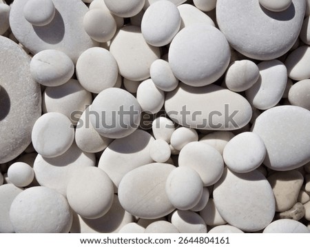Close-up of smooth white pebbles creating a natural, calming texture background for spa or design.