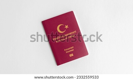A close-up snapshot featuring a Turkish passport positioned against a clean white backdrop, with the labels 
