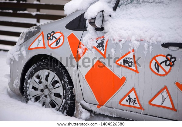 Close-up\
of snow covered car with orange color road\
signs