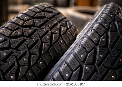closeup of snow tire with metal studs, which improve traction on icy surfaces, studded winter tyre