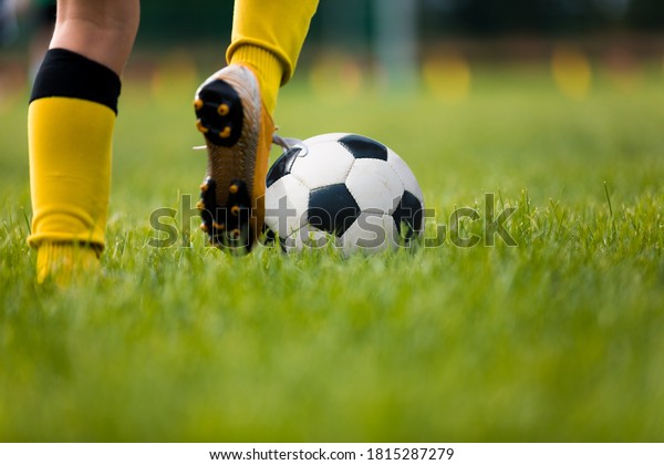 Closeup of soccer player running and kicking soccer
ball on grass lawn. Legs of footballer playing competition match.
Sports horiznotal background. Athlete in soccer cleats and soccer
socks