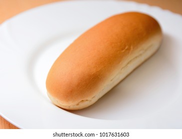 Closeup Of A Soft Plain Hot Dog Bun On A White Plate.