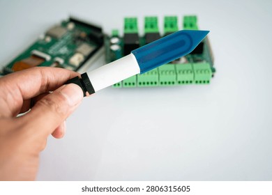 Close-up of a soil moisture sensor held by hand with electronic 