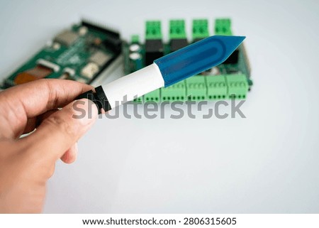 Close-up of a soil moisture sensor held by hand with electronic 