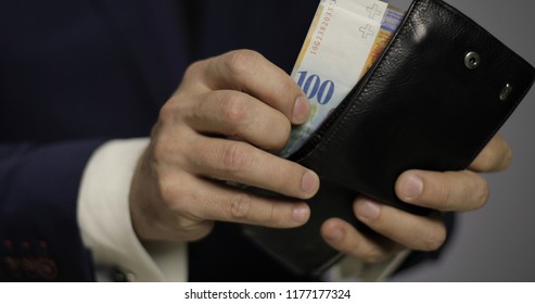 Close-up of a solid businessman pulls out the euro and Swiss francs from his wallet. Swiss currency of 200, 100 francs, 50 euro.