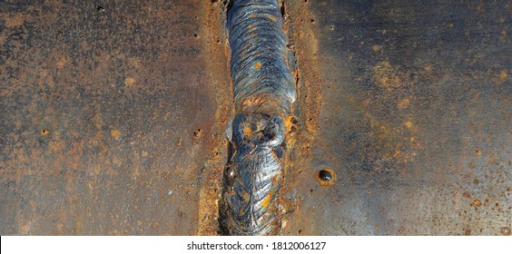 Closeup Of A Solidified Slag With Crater On A Welded Butt Joint. Two Metal Plates Welded Together As A Background