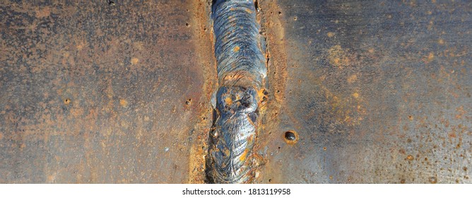Closeup of a solidified slag with crater on a welded butt joint. Two metal plates welded together as a background - Shutterstock ID 1813119958