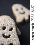 closeup of some cookies in the shape of a ghost, on a dark gray surface