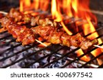 closeup of some meat skewers being grilled in a barbecue