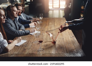 Close-up Sommelier Pouring Red Wine Into Decanter At Master Class In Restaurant On Tasting Drinks For Company Of Friends.