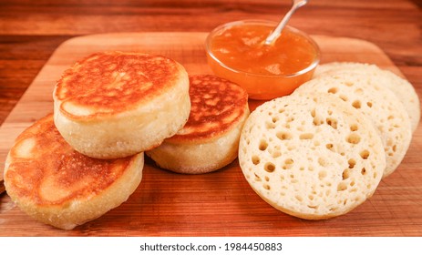 A Closeup Of Sourdough Crumpets With A Dip On A Wooden Boar