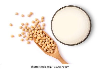 Closeup soy beans in wooden bowl and glass of soy milk isolated on white background. Top view. Flat lay.