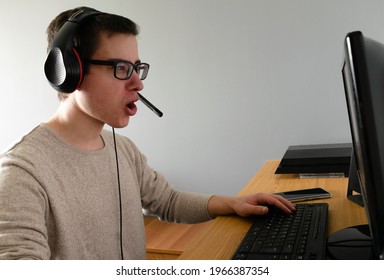 A Closeup Of A Spanish Caucasian Male Wearing A Headset And Using His Computer Indoors