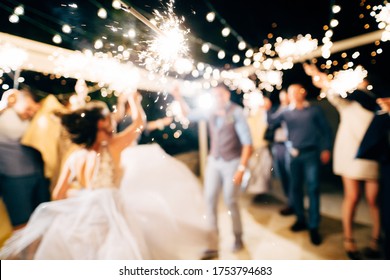 A close-up of the sparkler against the backdrop of the party.
