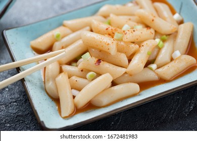 Closeup Of Spicy Korean Topokki Or Rice Cakes Served On A Turquoise Plate, Selective Focus