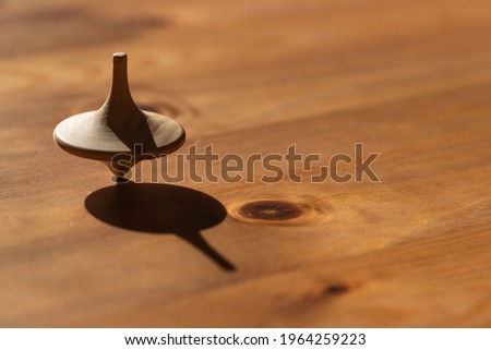 closeup of a spinning top symbolizing a fragile, unstable condition of balance achieved by constant movement like in the business world