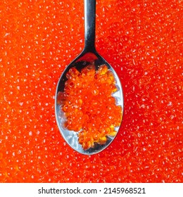 Close-up of a spoon with appetizing red caviar against the background of many caviar eggs. Seafood delicacies, top view. - Shutterstock ID 2145968521