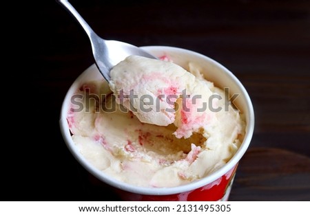 Closeup of spoon scooping delectable strawberry cheesecake ice cream