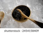 Close-up of a spoonful of luxurious black caviar, nestled on a bed of ice, ready to be served, highlighting the refined taste and texture of this gourmet delicacy.
