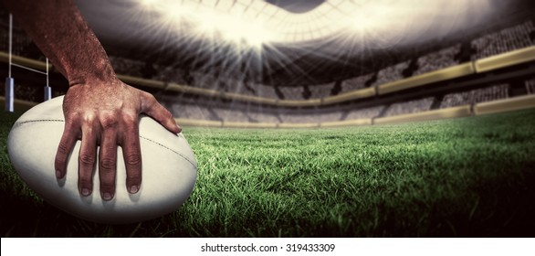 Крупный план спортивного игрока, держащего мяч против регби поле