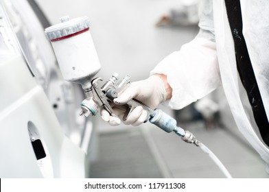 Close-up Of Spray Gun Painting A Car