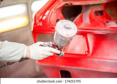 Close-up Of Spray Paint Gun Painting A Red Car In Painting Booth